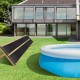 Weatherproof solar swimming pool heating system on grass, designed for efficient heating and energy saving.