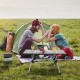 Folding heavy-duty aluminum camping table with adjustable height, set up for picnic in a grassy outdoor setting.