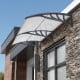 Gray outdoor front door patio awning with sturdy PC hollow panels for sunlight, rain, and wind protection.