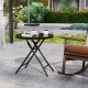 Round black folding side table with tempered glass top, ideal for outdoor use and easy to store.