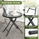 Round black folding side table with tempered glass top and reinforced X-shaped metal frame for indoor and outdoor use.