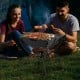 3-in-1 camping grill in use, featuring stainless steel construction, set up for BBQ with friends outdoors.