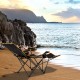 Folding camping chair with footrest and adjustable backrest, perfect for relaxing by the beach or outdoor activities.