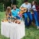4 feet plastic folding party table with matching skirt, filled with ice and drinks, ideal for outdoor gatherings.