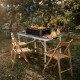 Folding grill table with iron mesh top, aluminum frame, and adjustable height, perfect for camping and outdoor BBQs.