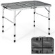 Folding grill table with aluminum frame and iron mesh top, adjustable height, perfect for camping and outdoor use.