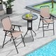Two beige folding chairs and a round glass table in an outdoor bistro set, ideal for patio or poolside use.