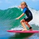 Child surfing on a pink lightweight bodyboard with leash, featuring durable EPS core and waterproof XPE deck for.