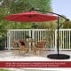 10 feet solar offset hanging umbrella in wine color with adjustable tilt, providing shade for outdoor dining areas.