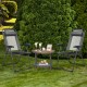 Two gray adjustable folding recliner chairs with a round coffee table, perfect for outdoor relaxation in the garden.