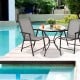 Two gray folding patio chairs with steel frames set around a round table, perfect for outdoor gatherings and camping.
