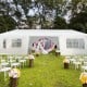 Outdoor canopy tent with removable sidewalls and doorways, ideal for events and parties in a garden setting.