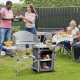 Foldable outdoor BBQ grilling table with windscreen, gray aluminum frame, ideal for camping and backyard parties.