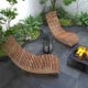 Two outdoor acacia wood rocking chairs with widened slatted seats, perfect for relaxing in the garden or patio.