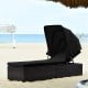Adjustable cushioned chaise lounge chair with folding canopy in black, perfect for beach or poolside relaxation.