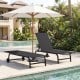 Black outdoor chaise lounge chair with wheels and metal frame, positioned by the poolside for relaxation.