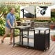 Portable outdoor grill cart table with stainless steel tabletops, hooks, and wheels for easy movement during BBQ gatherings.