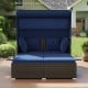 Outdoor patio rattan daybed in navy with retractable canopy and side tables, perfect for backyard relaxation.