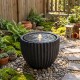 Outdoor round sphere water fountain with pump, featuring a realistic stone look and warm LED lights for garden.