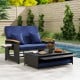 Outdoor wicker daybed with dark blue cushions and folding panels, perfect for patio relaxation and conversation.