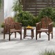 Two brown wooden patio armchairs with a small round table, perfect for outdoor relaxation and dining.