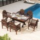 Outdoor wooden patio dining set featuring six brown armchairs and a large table, perfect for poolside dining.