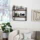 Wall-mounted bathroom shelf with metal frame, featuring two open storage shelves and a round towel bar for efficient.