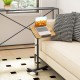 Rolling food tray table with adjustable height, 360° rotating surface, and wheeled base for easy mobility beside a sofa.