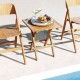 Patio folding side table made of teak wood with slatted tabletop, ideal for outdoor use and easy storage.