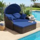 Patio PE rattan daybed with retractable canopy, navy cushions, and four throw pillows, ideal for comfortable outdoor lounging.