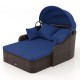 Patio PE rattan daybed with retractable canopy and navy cushions, perfect for lounging by the poolside or garden.