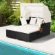 Patio rattan daybed with retractable canopy, off-white cushions, and side tables, perfect for poolside relaxation.