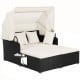 Patio rattan daybed featuring a retractable canopy and foldable side trays for convenient outdoor lounging.