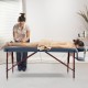 Portable folding massage table in navy with adjustable height, suitable for various therapies and easy to carry.