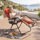 Portable zero gravity chair in orange with cup holder tray, perfect for outdoor relaxation and easy transport.