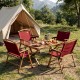 Portable red folding camping chairs with bamboo frames set around a table, perfect for outdoor picnics and leisure.