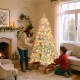 Pre-lit artificial Christmas tree with snow flocked branches, adorned with red berries and warm white LED lights for.