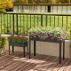 Elevated metal planter box set with legs, featuring drainage holes for healthy plant growth on a balcony.