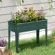 Elevated green metal gardening box with legs, featuring vibrant flowers, perfect for cultivating plants and herbs.