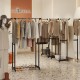 Rolling clothes rack with multiple rods, curved design to prevent wrinkles, and sturdy construction for reliable.