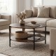 Round coffee table with rustic wood grain, showcasing a sturdy cross-shaped structure and ample clearance for easy.