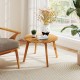 Round acacia wood side table with slatted design, showcasing its natural wood grain, ideal for balcony or garden.