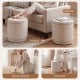 Round beige storage ottoman with removable lid, acacia wood frame, serves as footstool or side table for versatile use.