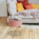 Round pink velvet footrest stool with gold metal frame, perfect as a side table or for comfortable seating.