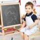 Kid sitting beside a height-adjustable wooden art easel with chalkboard and magnetic stickers for creative play.