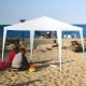10x10 feet outdoor canopy tent with removable sidewalls, providing shade and UV protection for beach gatherings.