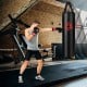 Boxer in training stance striking a hanging 63 lbs punching bag set, featuring durable PVC leather for effective.