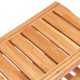 Close-up of the bamboo surface of a bathroom shower chair bench with a storage shelf, showcasing its smooth finish.