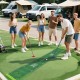 Putting green mat with adjustable putters and balls, perfect for outdoor fun with friends and family.