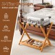 Folding luggage rack with acacia wood frame, nylon straps, and slatted storage shelf for organized bedroom use.